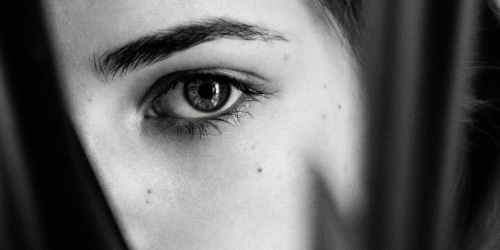 A close-up of an eye in black and white, symbolizing perception and the feeling behind why do I feel like I’m being watched.